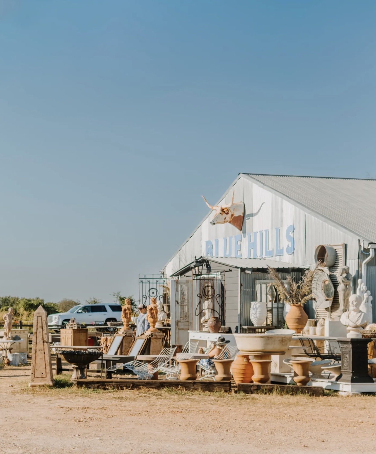 Antiques and sculptural objects outside the Blue Hills barn in Round Top